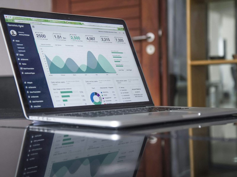 Laptop displaying website analytics charts on a bright, tidy desk surface
