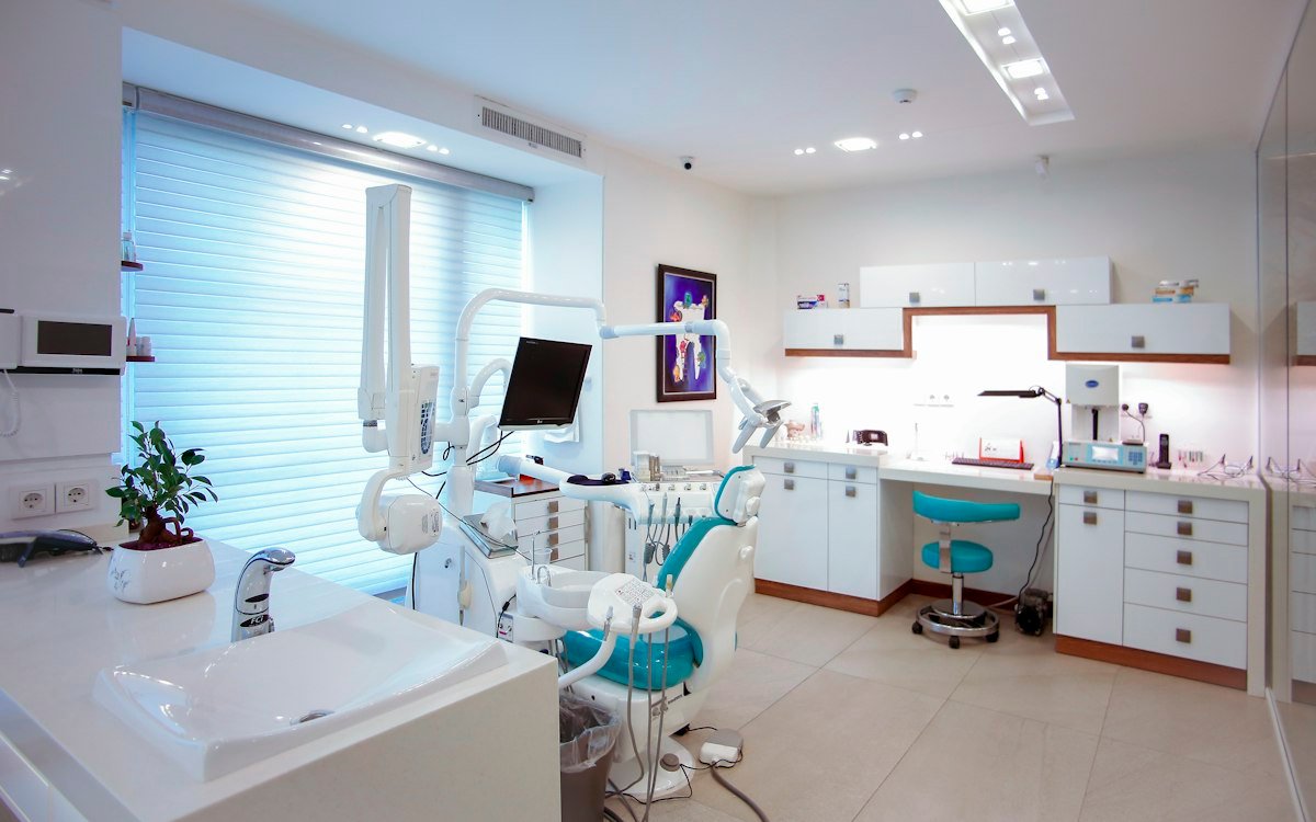 Bright modern dental clinic treatment room with clean white chair