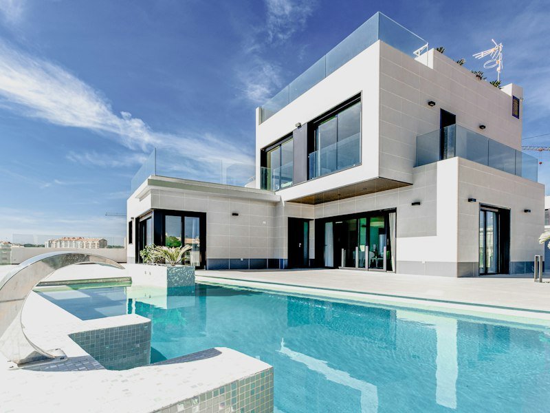Modern home exterior with clean lines, large windows, and landscaped garden