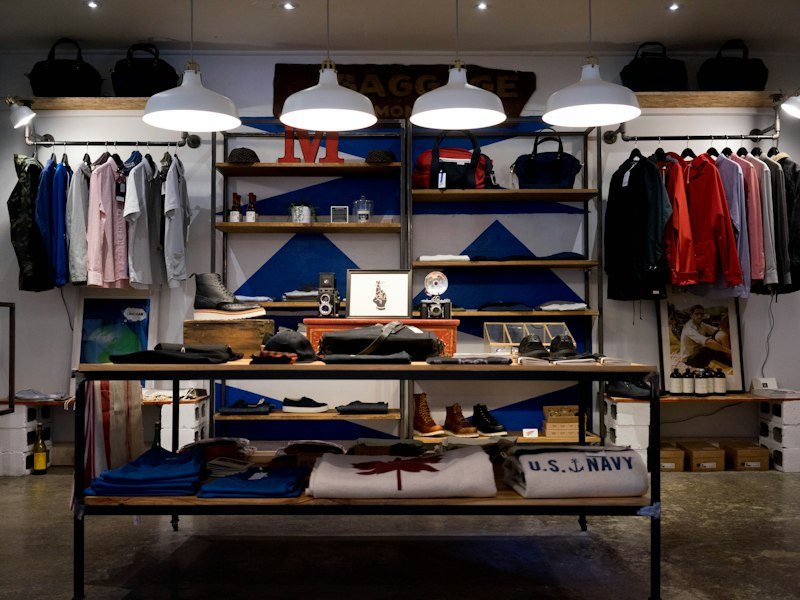 Boutique shop interior with tidy clothing rails and wooden display shelves