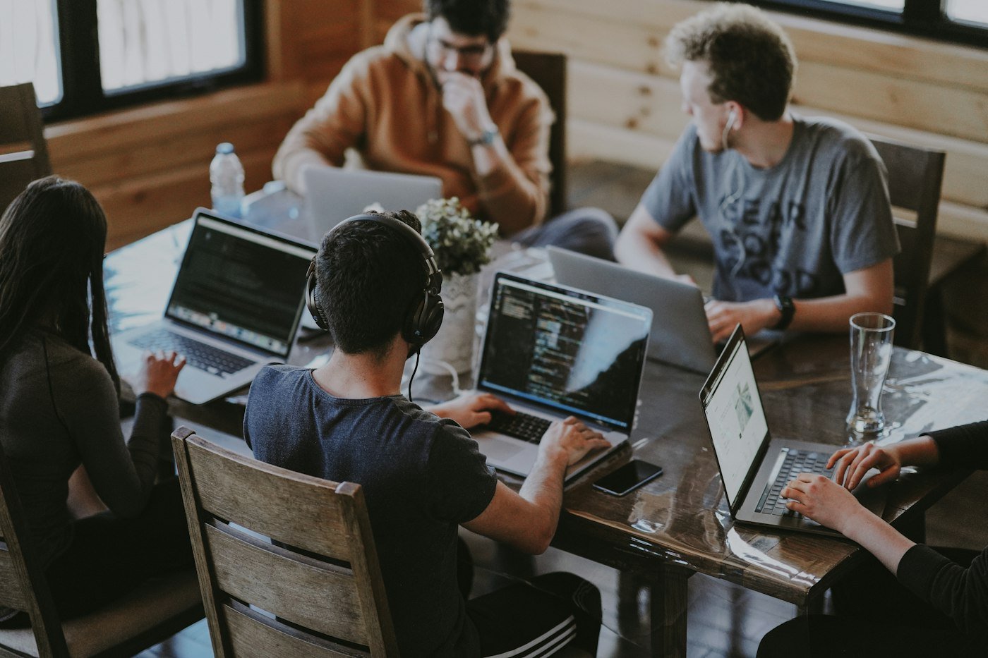 Small design team working together around a table with laptops and notes