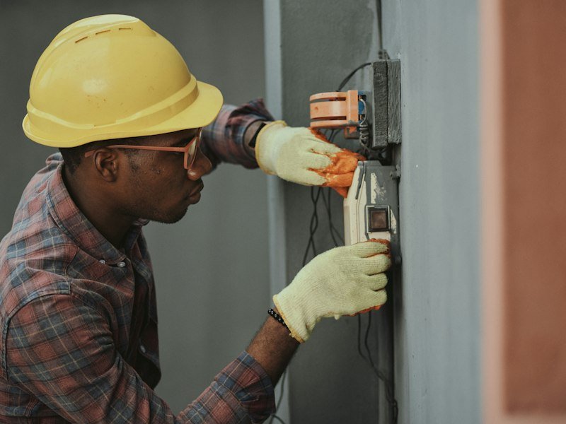 Tradesperson carefully working on an electrical installation inside a client home